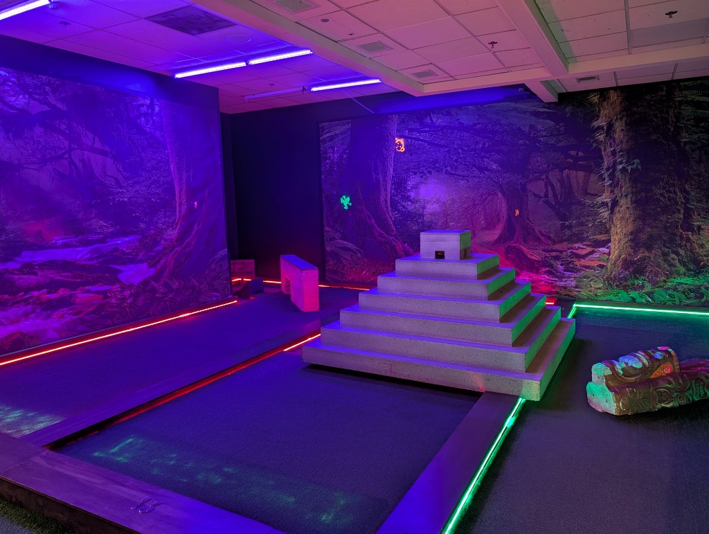 Glow-in-the-dark mini golf with Mayan temple obstacle and jungle murals