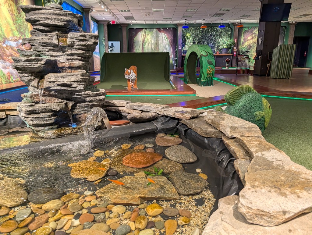 Rock waterfall, pond with goldfish, and themed mini golf obstacles